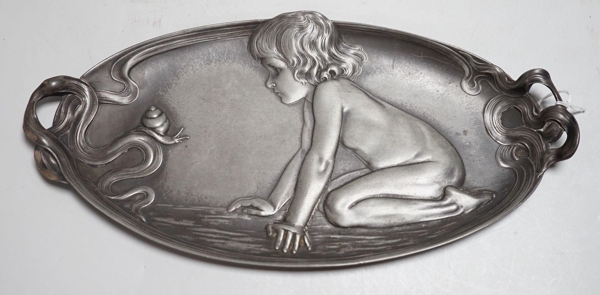 An unmarked, (possibly WMF) stamped 210 on base, an Art Nouveau pewter dish with a child admiring a snail. 27cm wide